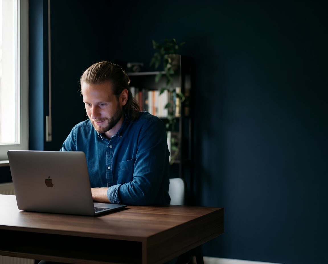Andy Schmitt arbeitet am MacBook
